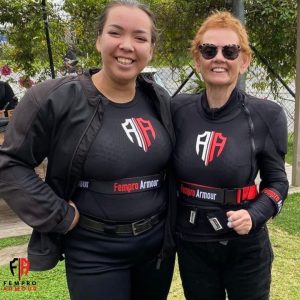 wo smiling women in motorcycle protective gear posing together outdoors